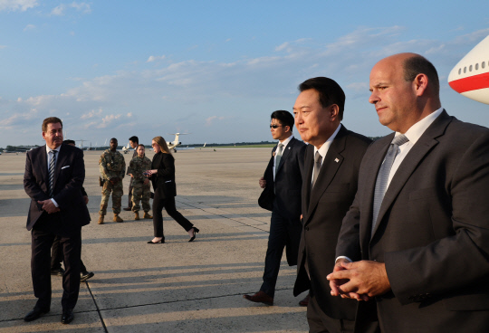 윤석열 대통령이 17일(현지시간) 미국 워싱턴DC 인근 앤드루스 공군기지에 도착, 공군 1호기에서 내린 뒤 영접 인사의 안내를 받고 있다. 윤 대통령은 미국 대통령의 공식 별장인 캠프 데이비드에서 18일(현지시간) 열리는 한미일 정상회의에 참석한다.      워싱턴=연합뉴스
